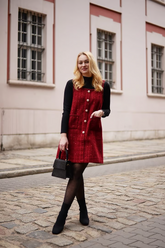 a lady in a black slim sweater and a red tweed dress
